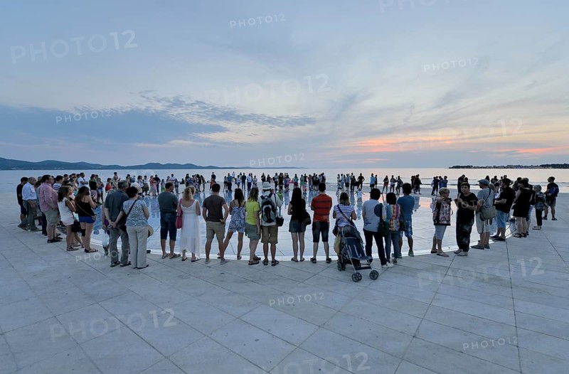 People at the Monument to the Sun, Pozdrav Suncu, by architect Nikole Bašica, at dusk, Zadar, Dalmatia, Croatia, Europe