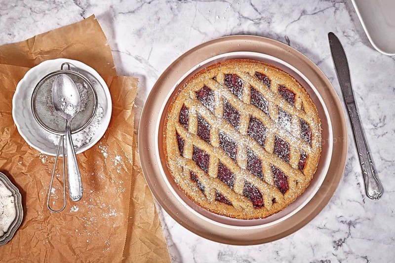 Top view of pie called 'Linzer Torte', a traditional Austrian shortcake pastry topped with fruit preserves and nuts with lattice design