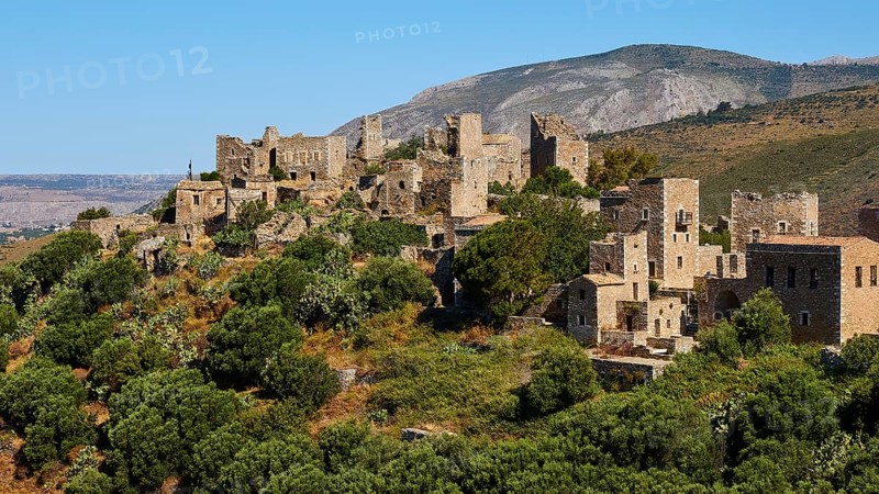 Historic stone buildings of a mountain village surrounded by trees and vast landscape, Vathia, residential tower village, Mani Peninsula, Peloponnese, Greece, Europe