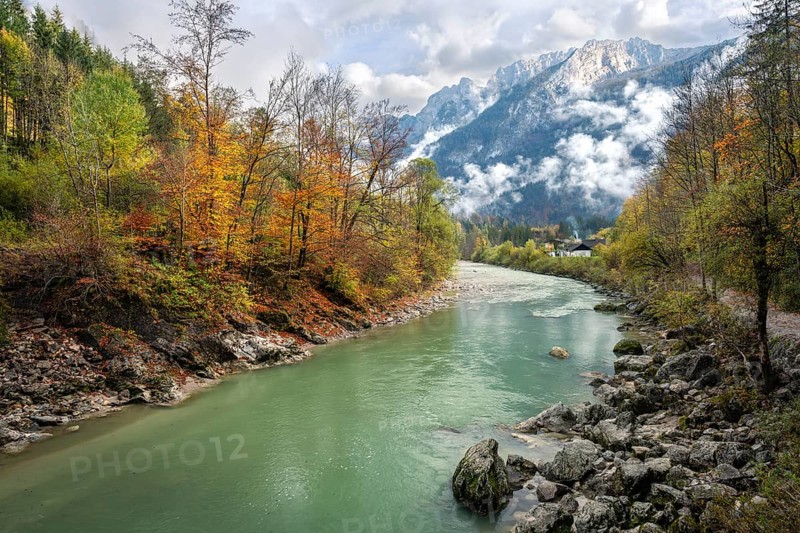 The River Lammer at the end of the Lammerklamm gorge. The Tennengebirge mountains in the background. Trees in autumn leaves. Clouds with some sun. Scheffau, Lammertal, Salzburger Land, Upper Austria, Austria, Europe