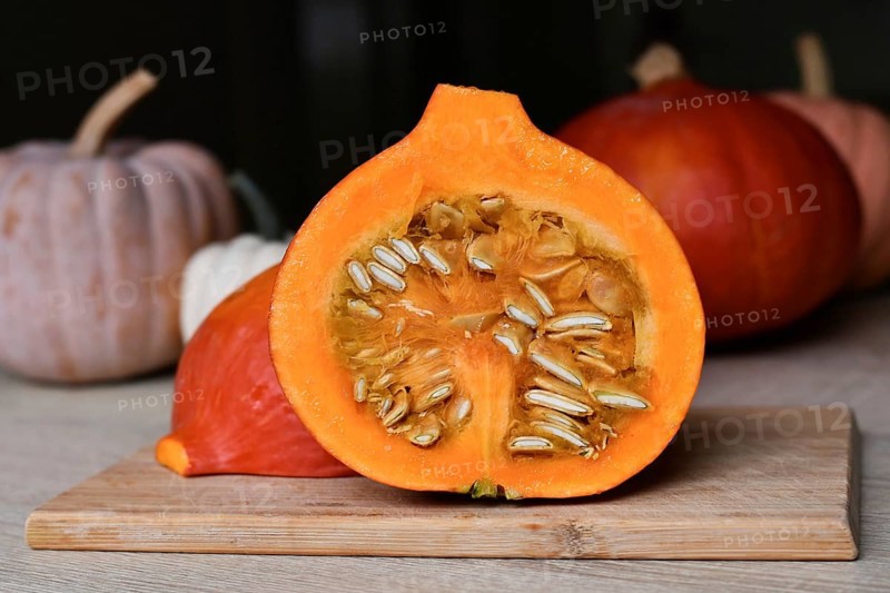 Halved Hokkaido pumpkin showing seed on cutting board in kitchen