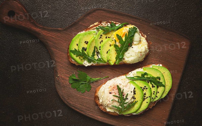 Sandwich with cream cheese, sliced avocado and boiled egg, arugula, on grainy bread, homemade, breakfast, no people
