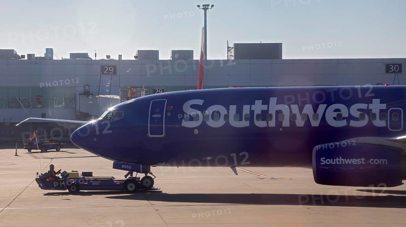 Oakland, California, A worker pushes a Southwest Airlines plane away from the gate at Oakland International Airport (OAK)