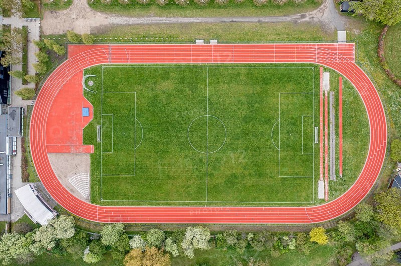 Aerial drone view of a soccer field with a red running track