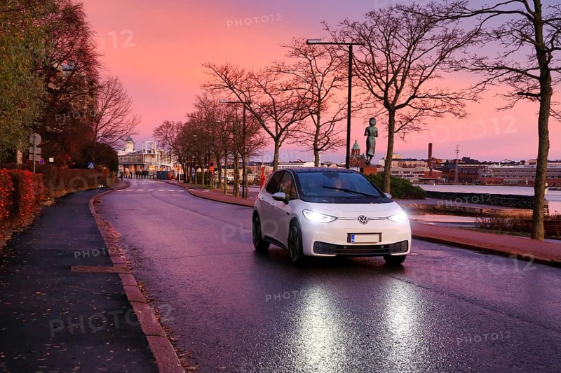 White Volkswagen ID3 electric car driving on seaside street at beautiful morning dusk, copy space. Helsinki, Finland. November 5, 2020