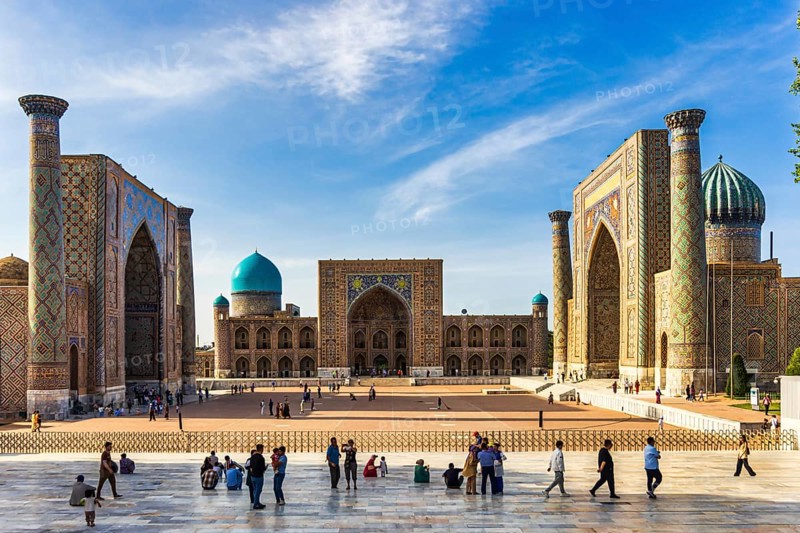 Registan square with three madrasahs and tourists on the observation platform