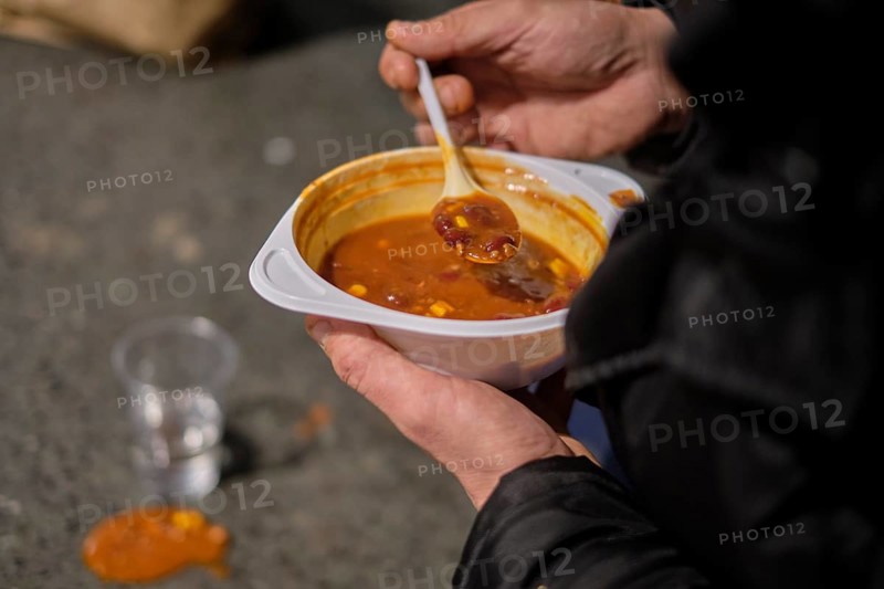 Germany, Berlin, 20.11.2020, On the road with the soup bus of the Berlin City Mission, Homeless man with bowl of chilli con carne, Europe