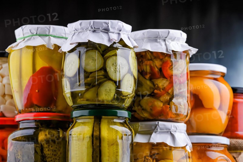 Jars with variety of marinated vegetables and fruits. Preserved food