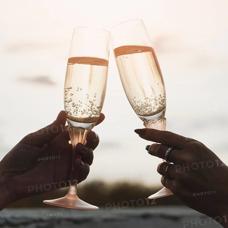 Women holding champagne glasses background sunset