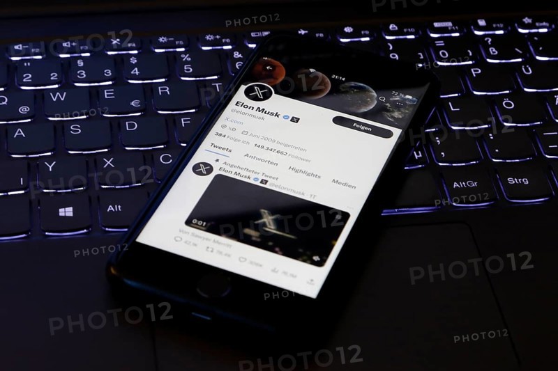 Symbolic image social media, close-up of a smartphone on illuminated computer keyboard with X logo on Elon Musk's account in the Twitter app, Germany, Europe