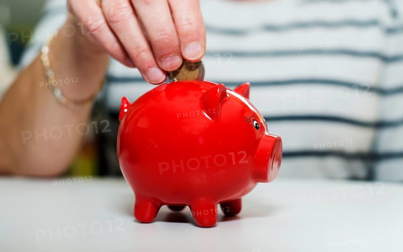 Female hand putting euro in money pig Female hand putting euro in money pig, saving money for later times