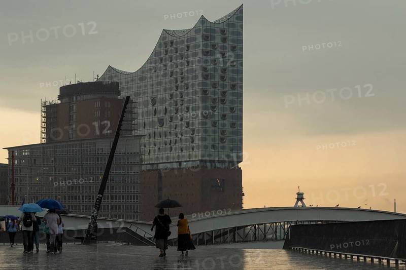 Symbolic picture weather, heavy rain in summer, thunderstorm, storm, tourists with umbrella in the rain in front of the Elbe Philharmonic Hall at the Landungsbrücken in the harbour of Hamburg, Germany, Europe