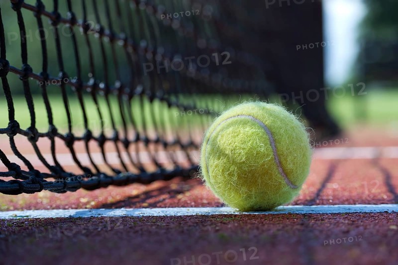 Tennis ball in the net. Ball hitting the tennis net, tennis scene with black net and yellow ball