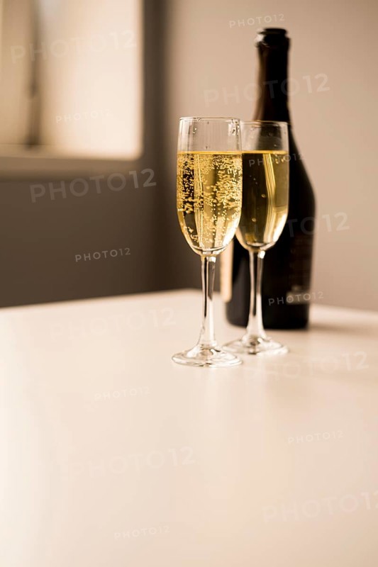 Champagne glasses with bottle white table