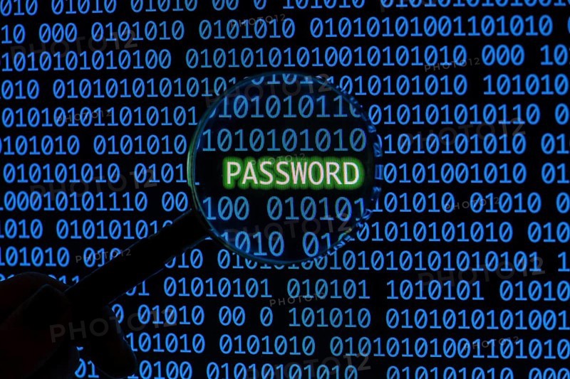 Password with binary code hand holding magnifying glass