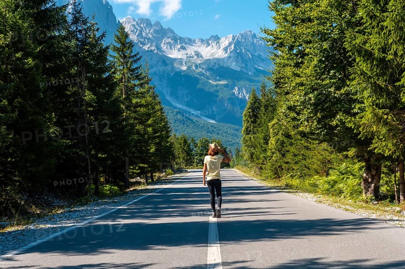 A woman walking on the road in the Valbona Valley, Theth National Park, Albanian Alps, Valbona Albania