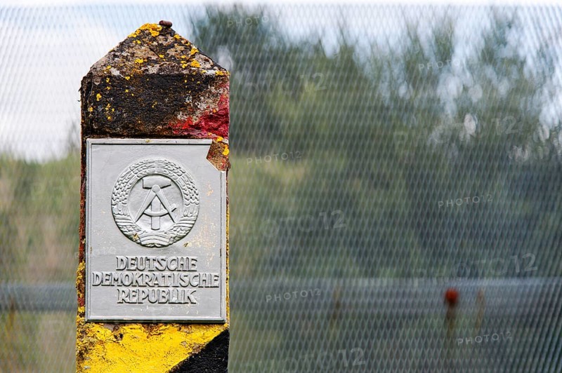 Old border post in front of a border fence on the former inner-German border