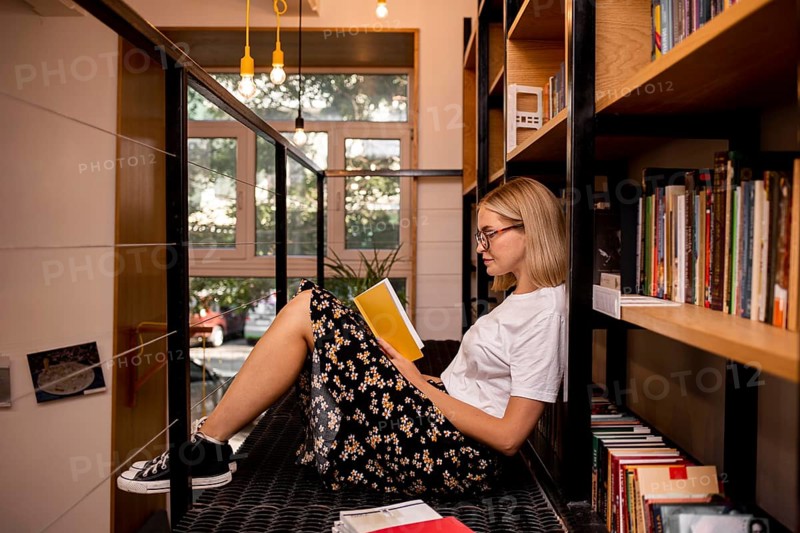 Student reading book library