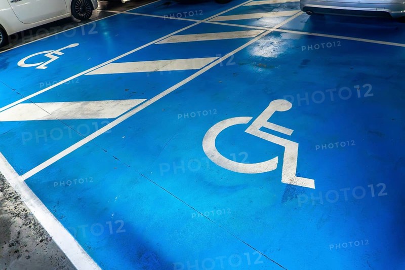A parking lot with a blue handicap parking sign