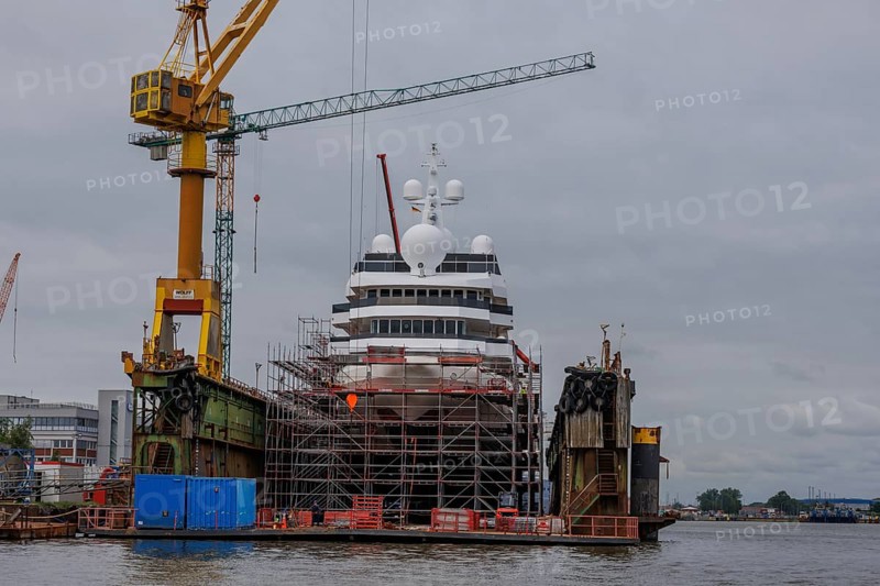 A large ship being repaired or rebuilt in a shipyard, surrounded by scaffolding and cranes, Bremerhaven, Bremen, Germany, Europe
