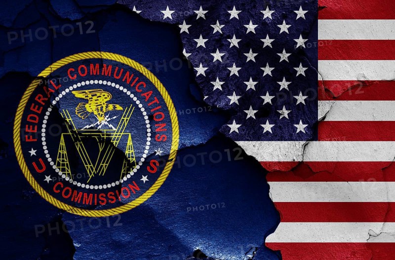 Flags of Federal Communications Commission and USA painted on cracked wall