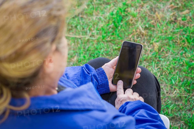 Close up of a woman's wrinkled finger, touching on a cell phone