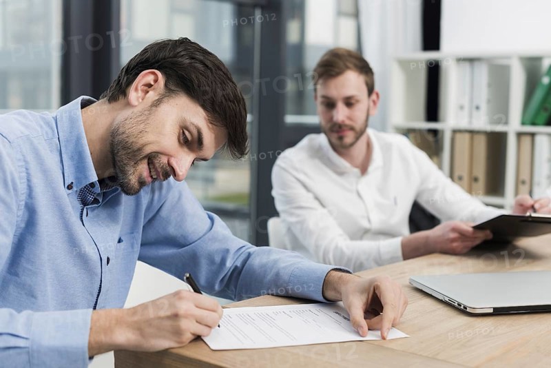 Side view smiley man signing work contract
