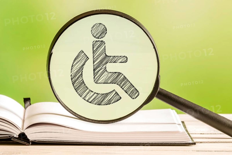 Handicapped info with a pencil drawing of a disabled icon in a magnifying glass