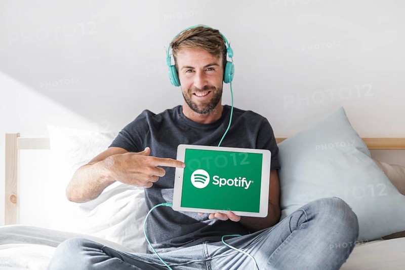 Young man holding tablet with spotify app