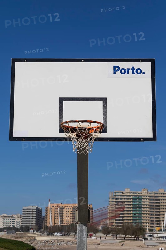 Basketball hoop in front of a blue sky with Porto lettering on the beach promenade in Matosinhos, Norte region, Porto district, Portugal, Europe