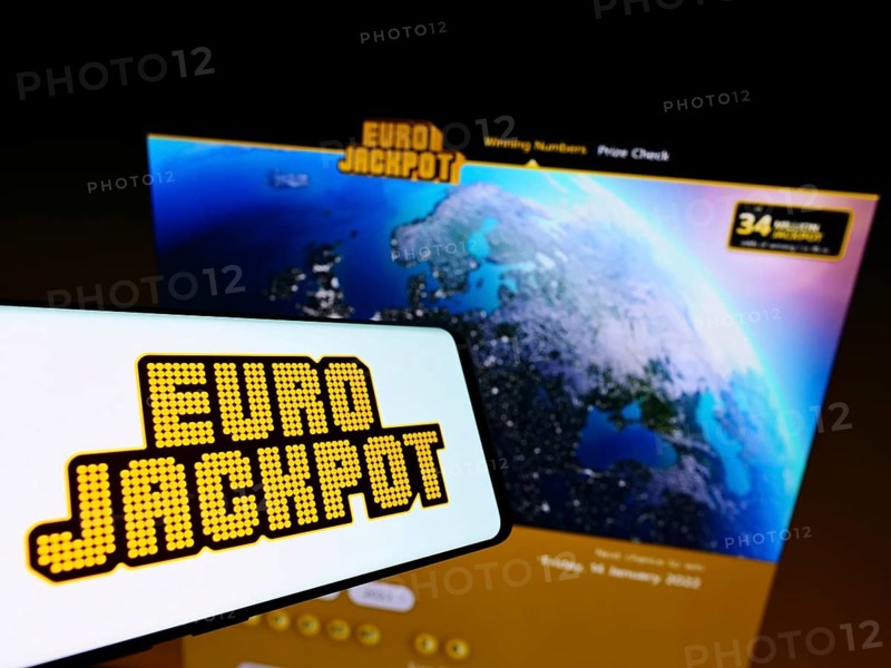 Stuttgart, Germany, 01-08-2022: Mobile phone with logo of transnational European lottery Eurojackpot on screen in front of business website. Focus on center of phone display, Europe