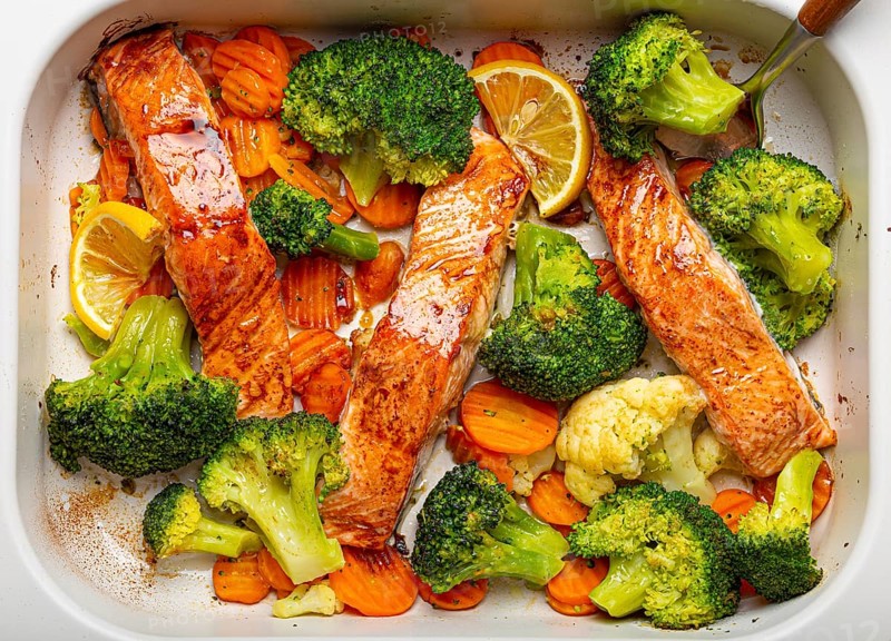 Top view close up of healthy baked fish salmon steaks, broccoli, cauliflower, carrot in casserole dish. Cooking a delicious low carb dinner, healthy nutrition concept, food photography, food photography