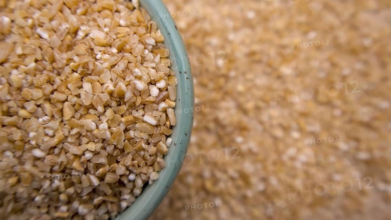 Cracked Broken Wheat Porridge (Dalia) in a Blue Bowl, Top View, Flat Lay, Closeup