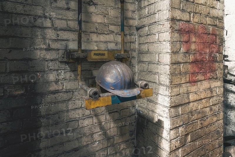 Old abandoned industrial building with a helmet hanging on a brick wall, surrounded by shadows, steelworks HF4, Lost Place, Dampremy, Charleroi, Province of Hainaut, Belgium, Europe