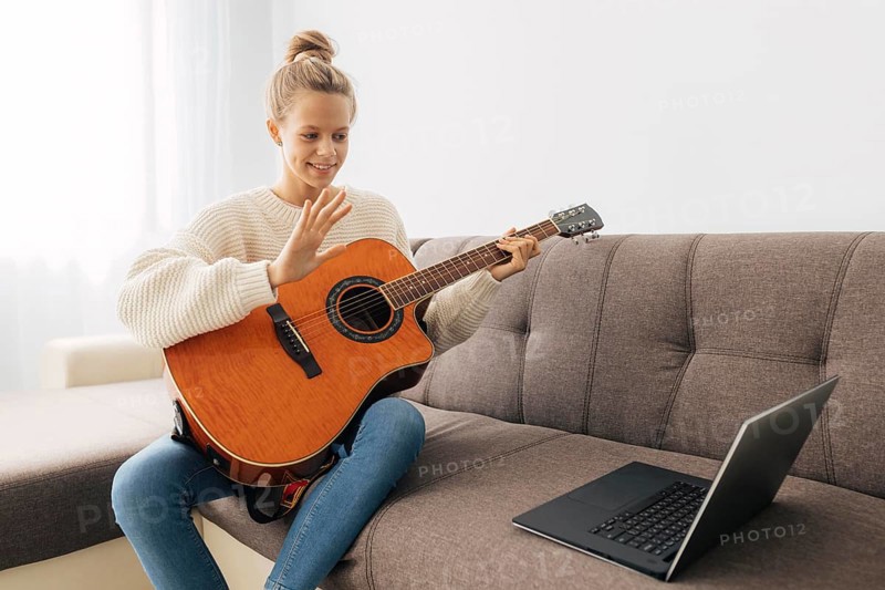 Young girl playing guitar home