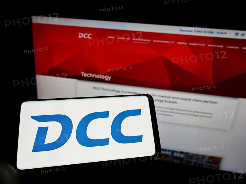 Stuttgart, Germany, 06-04-2022: Person holding cellphone with logo of Irish sales and marketing company DCC plc on screen in front of business webpage. Focus on phone display, Europe