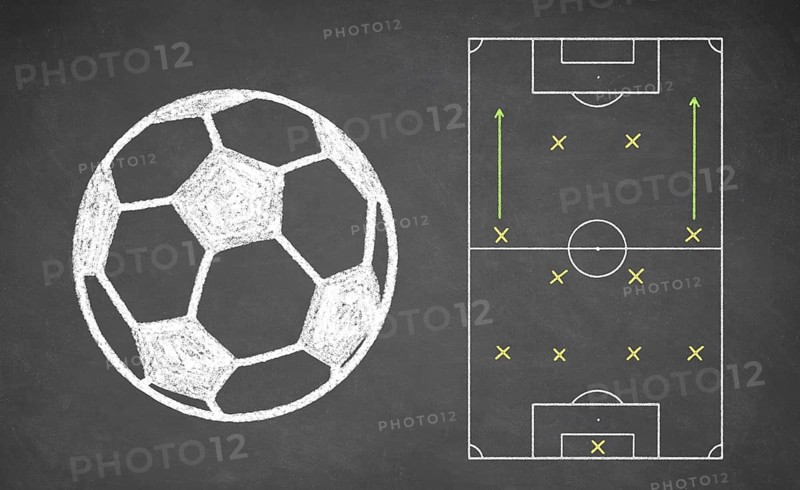 Soccer ball and tactical scheme drawn on chalkboard. White chalk and balckboard