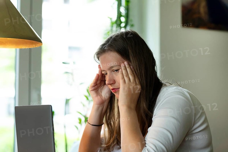 Young woman suffers from burnout in home office on laptop, Freiburg, Baden-Württemberg, Germany, Europe