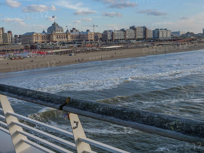 City on the beach with a view of the sea, pier and people along the coast, scheveningen, the netherlands