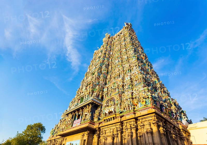 West tower gateway of Meenakshi Amman Temple covered in colorful statues of gods on a blue sky day at Madurai in south Indian state of Tamil Nadu, India, Asia