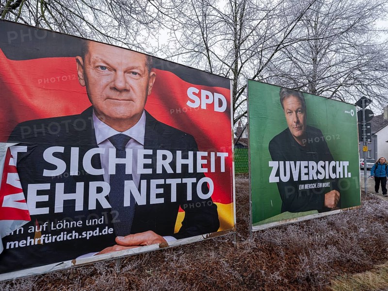 Election posters for the federal election on 23 February 2025 of the SPD party with a portrait of Federal Chancellor Olaf Scholz with the (partly torn off) slogan MIT SICHERHEIT MEHR NETTO and a poster of Bündnis 90/Die Grünen with a portrait of the candidate for chancellor, Minister of Economic Affairs Robert Habeck, and the text ZUVERSICHT. ONE PEOPLE, ONE WORD, Brunswick, Lower Saxony, Germany, Europe