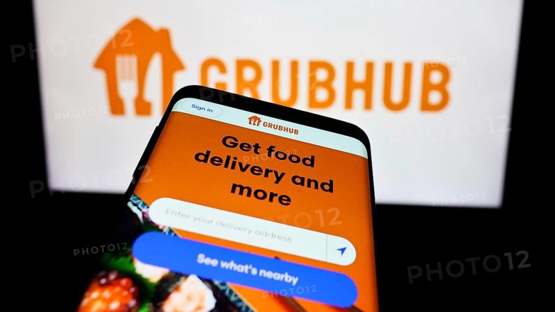 Stuttgart, Germany, 11-22-2023: Smartphone with website of US food ordering and delivery company Grubhub Inc. in front of business logo. Focus on top-left of phone display, Europe