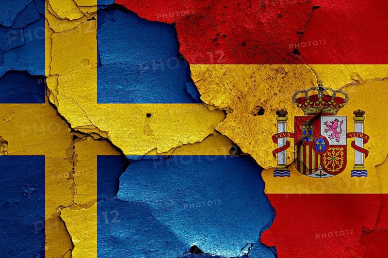 Flags of Sweden and Spain painted on cracked wall