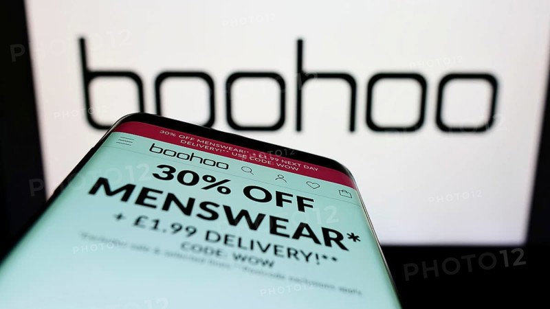 Stuttgart, Germany, 05-28-2022: Mobile phone with website of British fashion company Boohoo Group plc on screen in front of business logo. Focus on top-left of phone display, Europe