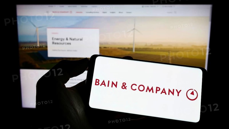 Stuttgart, Germany, 06-11-2022: Person holding cellphone with logo of US consulting company Bain and Company Inc. on screen in front of business webpage. Focus on phone display, Europe