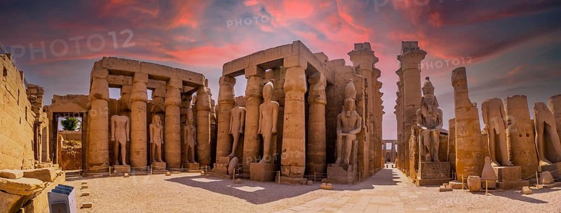Sculptures of ancient Egyptian pharaohs and drawings on the columns of the Luxor Temple in the evening. Egypt