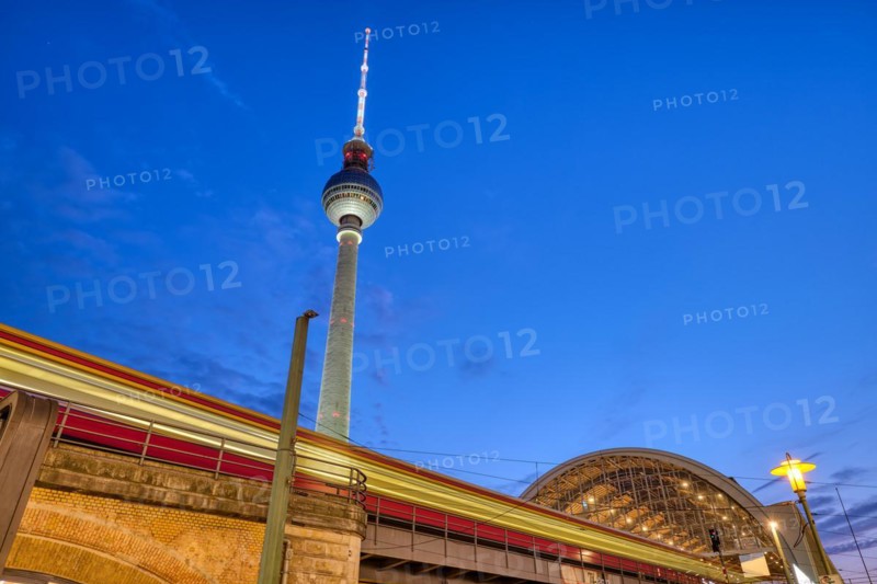 Local train entering Alexanderplatz station in Berlin at dusk