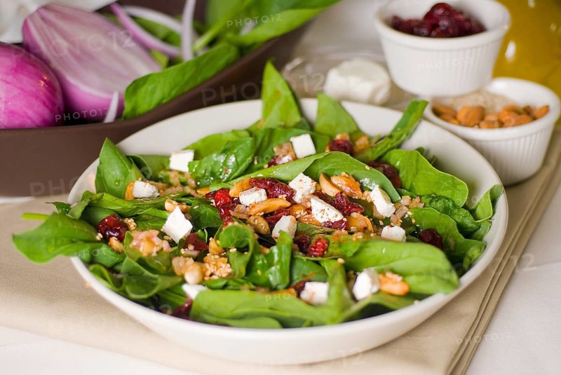 Plate of fresh colorfull spinach salad close up