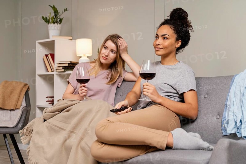 Women couch watching tv drinking wine