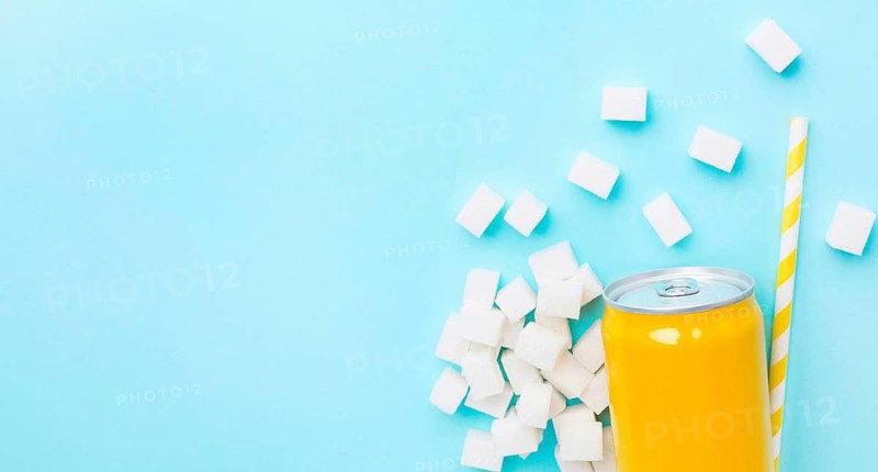 Flat lay soft drink can with sugar cubes straw